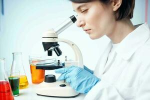 female laboratory assistant research science microbiology analyzes photo