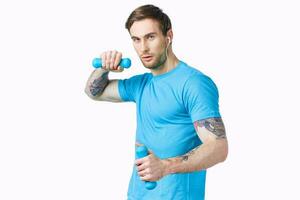 sport man in blue t-shirt holding dumbbells fitness exercise cropped view photo
