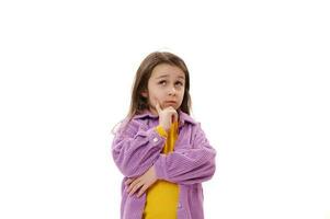 Clever little kid girl looks aside up, reasoning over idea, putting hand prop up on chin iterates over solution options photo