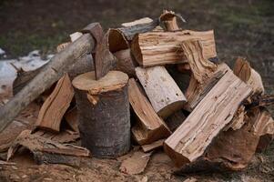 el concepto de el cortar madera para fuego calor. todavía vida composición con hacha y leña en el patio interior en rústico estilo foto