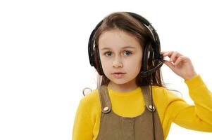 adorable pequeño niña vistiendo auriculares para en línea educación o distancia aprendiendo, mirando a cámara, aislado en blanco foto