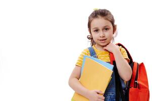 Horizontal portrait of Caucasian first grader schoolgirl, holding books, smiling at camera, isolated on white background photo