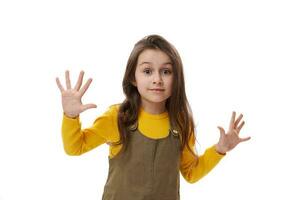 Adorable cheerful baby girl looking attentively at camera, showing her hands palms up, isolated on white background. photo