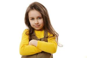 Close-up portrait of adorable little girl posing with hers arms folded over white isolated background photo