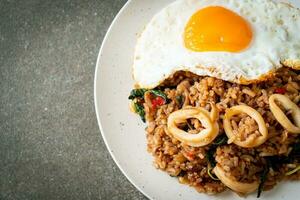 fried rice with squid and basil topped fried egg in Thai style photo