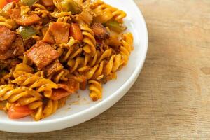 fusilli pasta with ham and tomatoes sauce photo