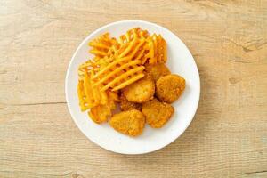 fried chicken nuggets with fried potatoes photo