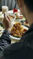 Man eating fried rice in a restaurant, back view of hands photo
