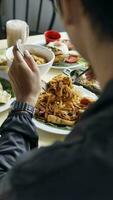 hombre comiendo frito arroz en un restaurante, espalda ver de manos foto