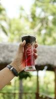 grated cucumber ice with red syrup in a long glass photo