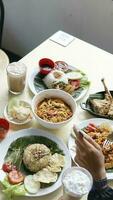 Top view of man eating noodles with spoon and fork photo