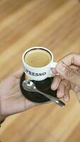 Close up of a cup of coffee in a man's hand. photo