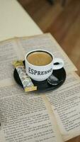 Coffee cup on book in coffee shop, vintage style. photo