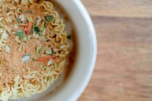 instant noodles with seasonings, on a wooden background, top view photo