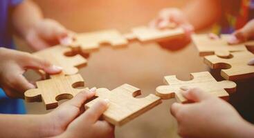 jigsaw in hand puzzle pieces gather together teamwork The concept of planning work as a team. photo