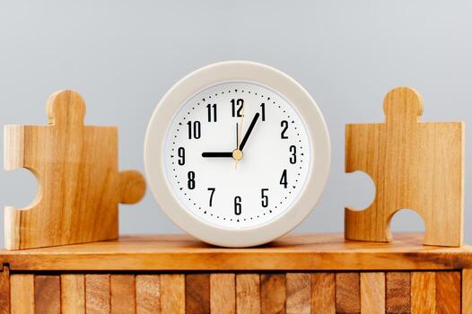 Clock next to the jigsaw puzzle piece working against time concept of time value of time photo