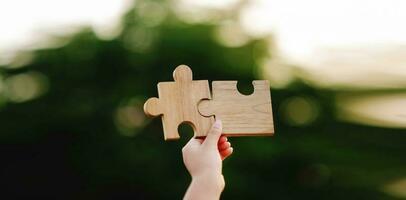 jigsaw in hand puzzle pieces gather together teamwork The concept of planning work as a team. photo