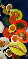 Seafood dish served on the table and plate from above with different kind of dish from fried fish barracuda, snapper, tuna jaws, and also mix of tropical vegetables photo