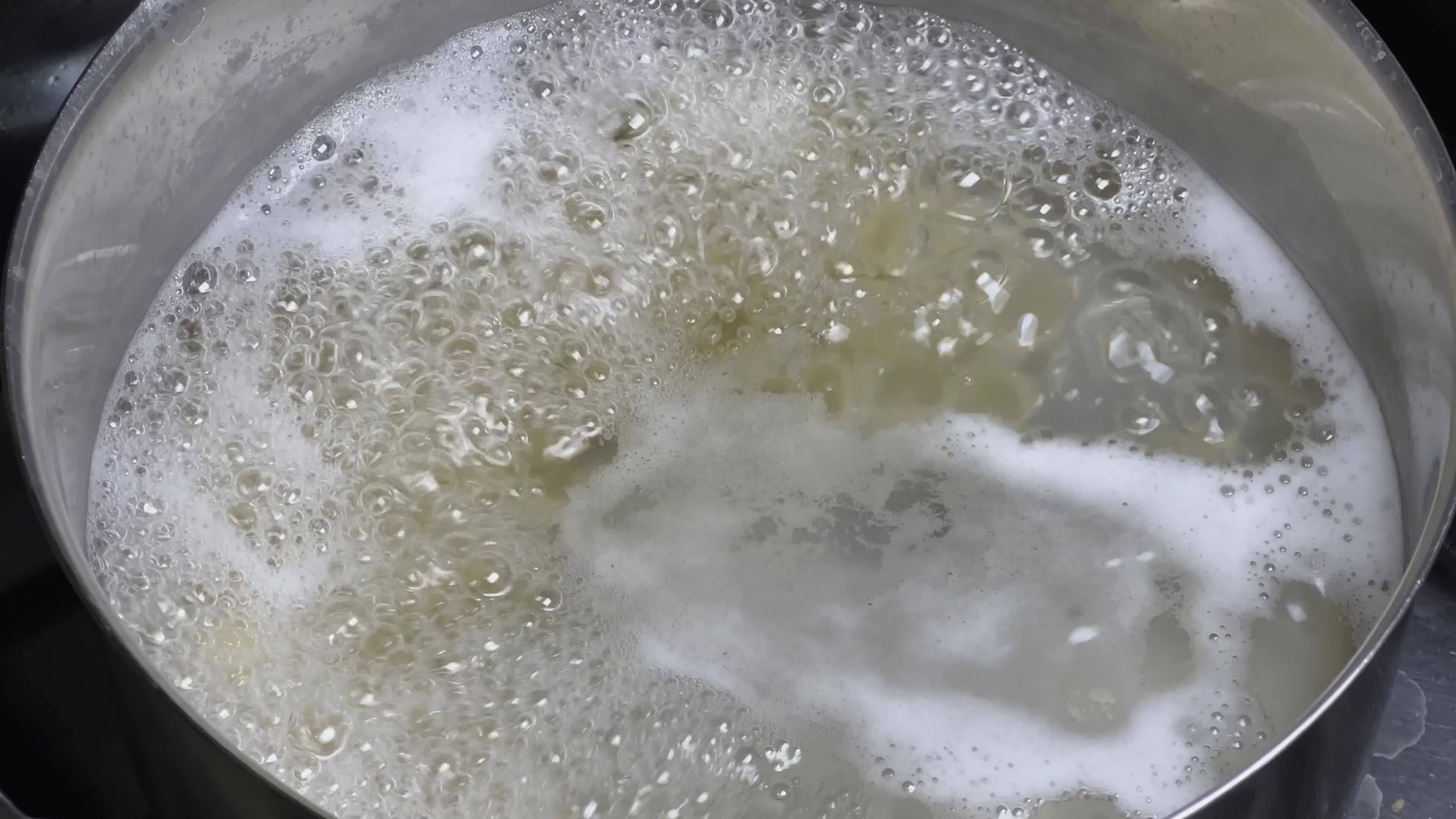 White foam in a pot of boiling water on a stove. 23740363 Stock Video