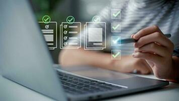 Prepare check and approve concepts. Document management, paperless. Women touching on virtual screen to tick mark documents for online approve paperless quality assurance and ERP management. photo