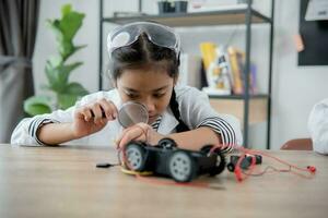 los estudiantes asiáticos aprenden en casa a codificar autos robot y cables de tableros electrónicos en tallo, vapor, ingeniería matemática, ciencia, tecnología, código de computadora en robótica para el concepto de niños. foto