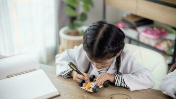 los estudiantes asiáticos aprenden en casa a codificar autos robot y cables de tableros electrónicos en tallo, vapor, ingeniería matemática, ciencia, tecnología, código de computadora en robótica para el concepto de niños. foto