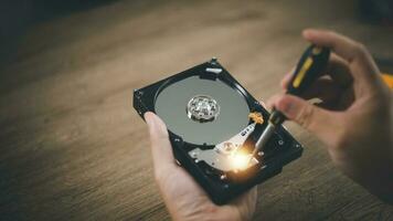 Close up of hard disk internal mechanism hardware. HDD in hand with a screwdriver photo