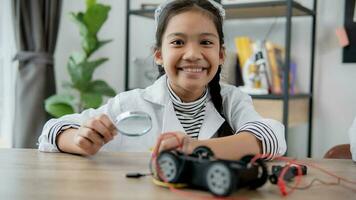 los estudiantes asiáticos aprenden en casa a codificar autos robot y cables de tableros electrónicos en tallo, vapor, ingeniería matemática, ciencia, tecnología, código de computadora en robótica para el concepto de niños. foto