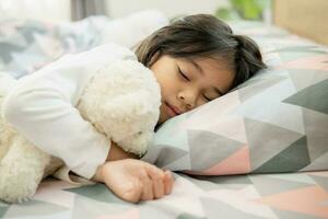 linda pequeño niña dormido en cama con suave almohadas a hogar foto