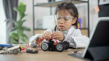 los estudiantes asiáticos aprenden en casa a codificar autos robot y cables de tableros electrónicos en tallo, vapor, ingeniería matemática, ciencia, tecnología, código de computadora en robótica para el concepto de niños. foto