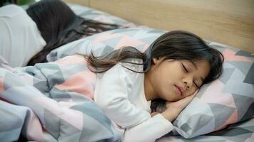 linda pequeño niña dormido en cama con suave almohadas a hogar foto