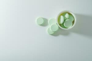 A bunch of medicinal pills and antibiotics, White medical tablets, light green, with copy space. photo