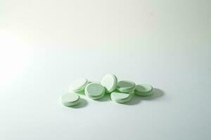 A bunch of medicinal pills and antibiotics, White medical tablets, light green, with copy space. photo