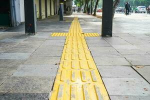 Pedestrian paths, Braille block in tactile paving for the blind handicapped in tiled pathways, paths for the blind. photo