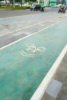 bicycle lane, traffic, city transportation and eco-friendly concept, green bicycle lane with bicycle signs photo