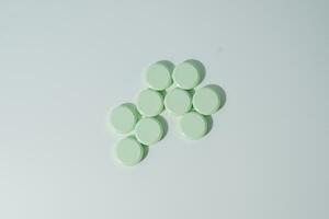 A bunch of medicinal pills and antibiotics, White medical tablets, light green, with copy space. photo