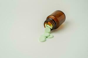 Group of medicine pills and antibiotics, White medical tablets, light green, in brown glass bottles, with copy space. photo