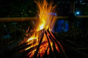 bonfire and some sparks on the camping ground, with citylight in the background photo