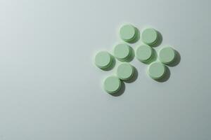 A bunch of medicinal pills and antibiotics, White medical tablets, light green, with copy space. photo