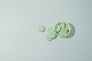 A bunch of medicinal pills and antibiotics, White medical tablets, light green, with copy space. photo