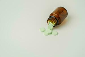 Group of medicine pills and antibiotics, White medical tablets, light green, in brown glass bottles, with copy space. photo