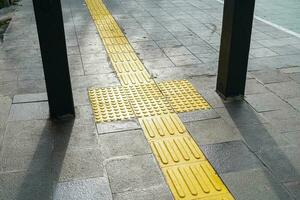 Pedestrian paths, Braille block in tactile paving for the blind handicapped in tiled pathways, paths for the blind. photo