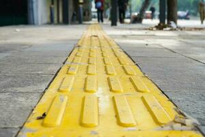 Pedestrian paths, Braille block in tactile paving for the blind handicapped in tiled pathways, paths for the blind. photo