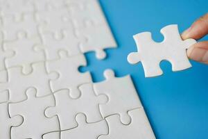 Closeup hand  connecting jigsaw puzzle with sunlight effect, Business solutions, success and strategy concept photo