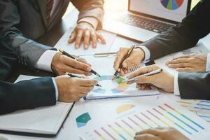 Businessman analyzing cost graph on table Brainstorm ideas, concepts, unity, teamwork, planning, success at work. photo