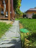 drainage systems. metal construction from the roof - sewer and grate on the ground for draining water closeup. sunny day, green grass photo