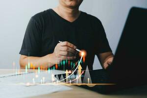man draw growth graphs and progress of business and analyze financial, and investment.Use technology to plan strategy to success goals and growth stock.online business, e-commerce, online marketing. photo