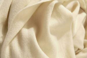 Natural wool yellow colored fabric. Cashmere, wool. Texture of natural wool fabric. Knitwear. photo