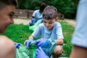Group of kids volunteers cleaning together a public park. They are picking up garbage. photo