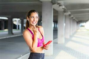 young beautiful woman jogging, fitness outfit, listening to music on headphones, smartphone, sea sunrise, skinny perfect slim body, healthy living lifestyle, summer, smiling, happy photo